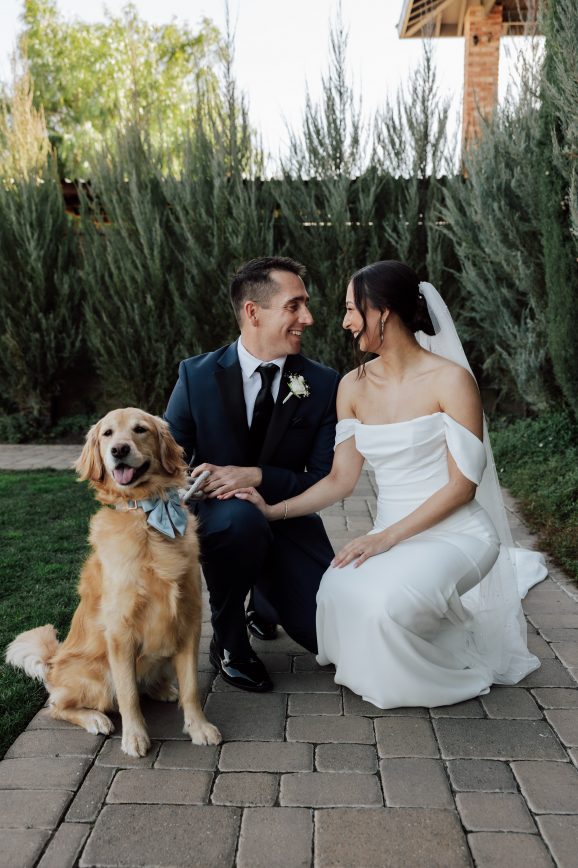 Bride and groom with dog at wedding.